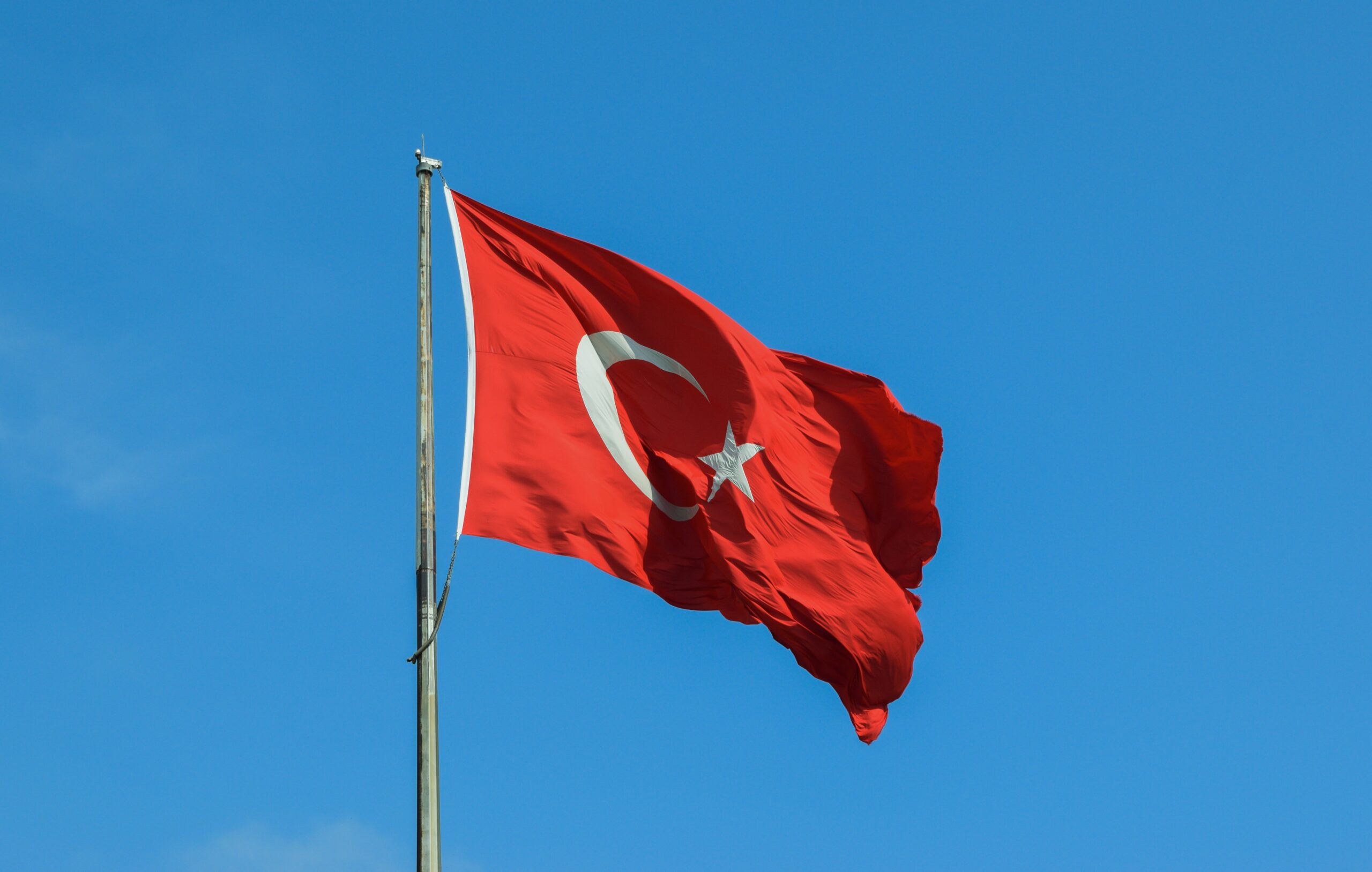 Flag of Turkey flying against blue sky